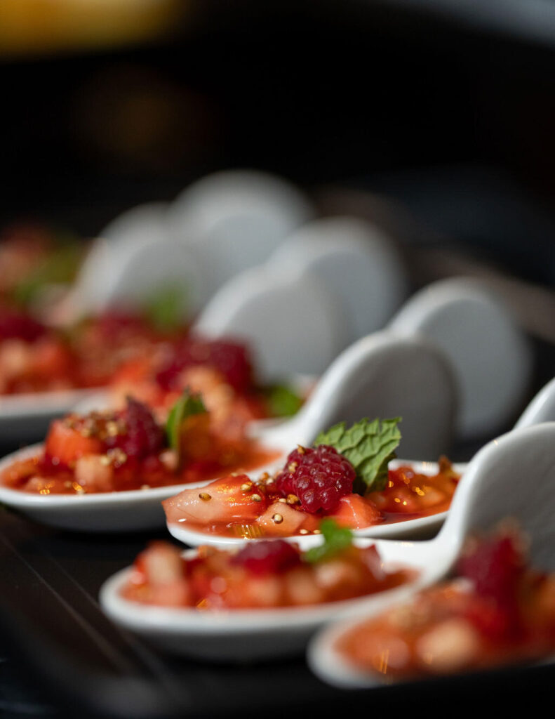 Small bowls of non traditional wedding food, like berries in individual ceramic spoons.